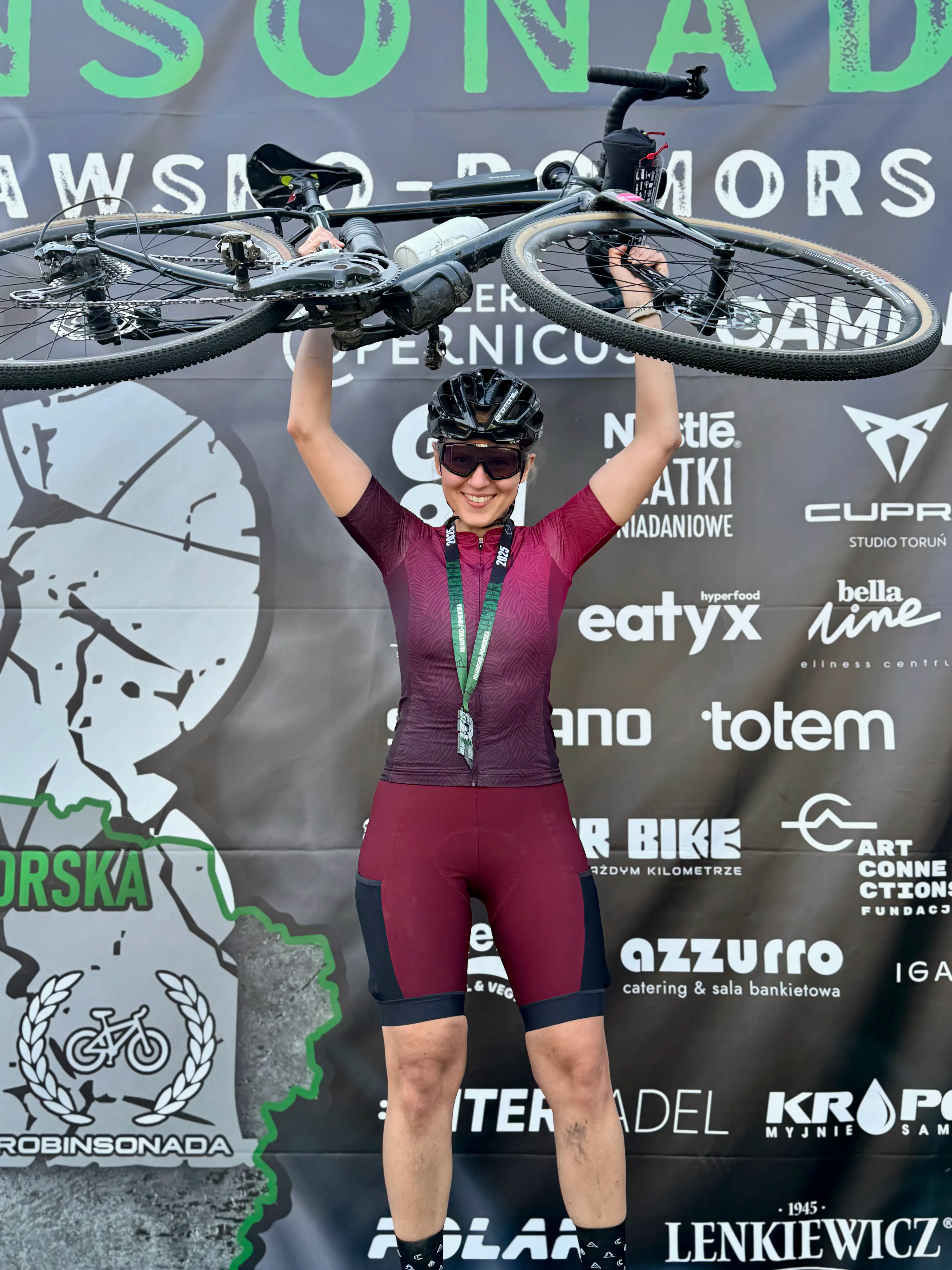 Holding the bike overhead at the finish of a gravel race